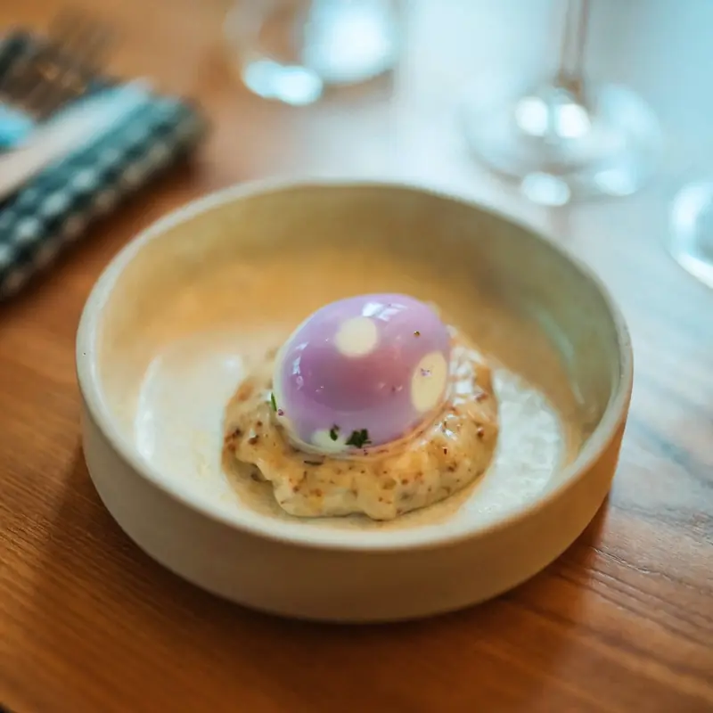 L’œuf mayo du Bistro Sauvage, rose d’hibiscus, dans une assiette creuse en céramique.